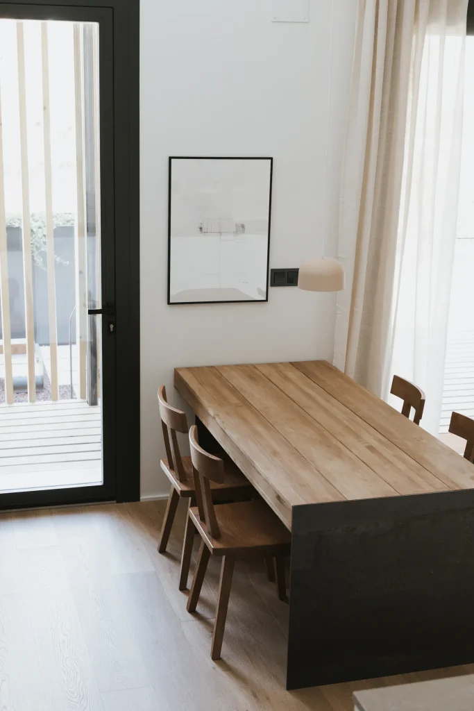 Mesa de comedor del apartamento 4 junto a los ventanales de la terraza.