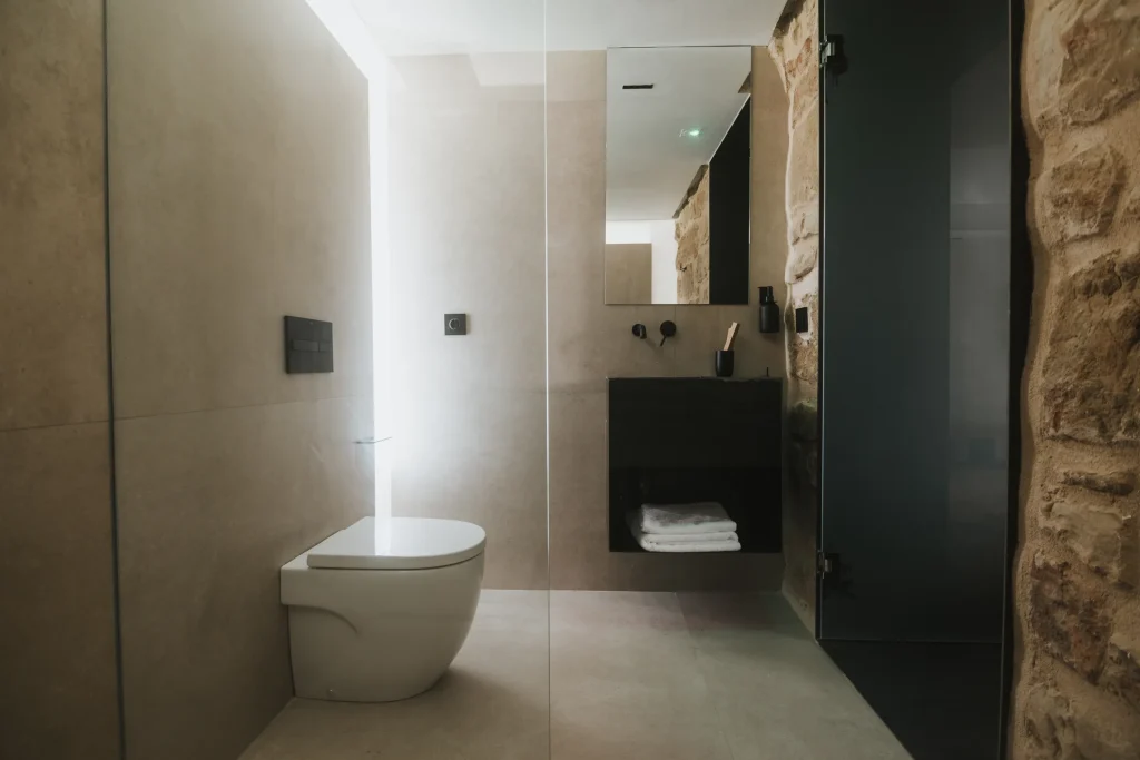 Baño del apartamento 4 con lavabo, espejo y mampara de cristal.