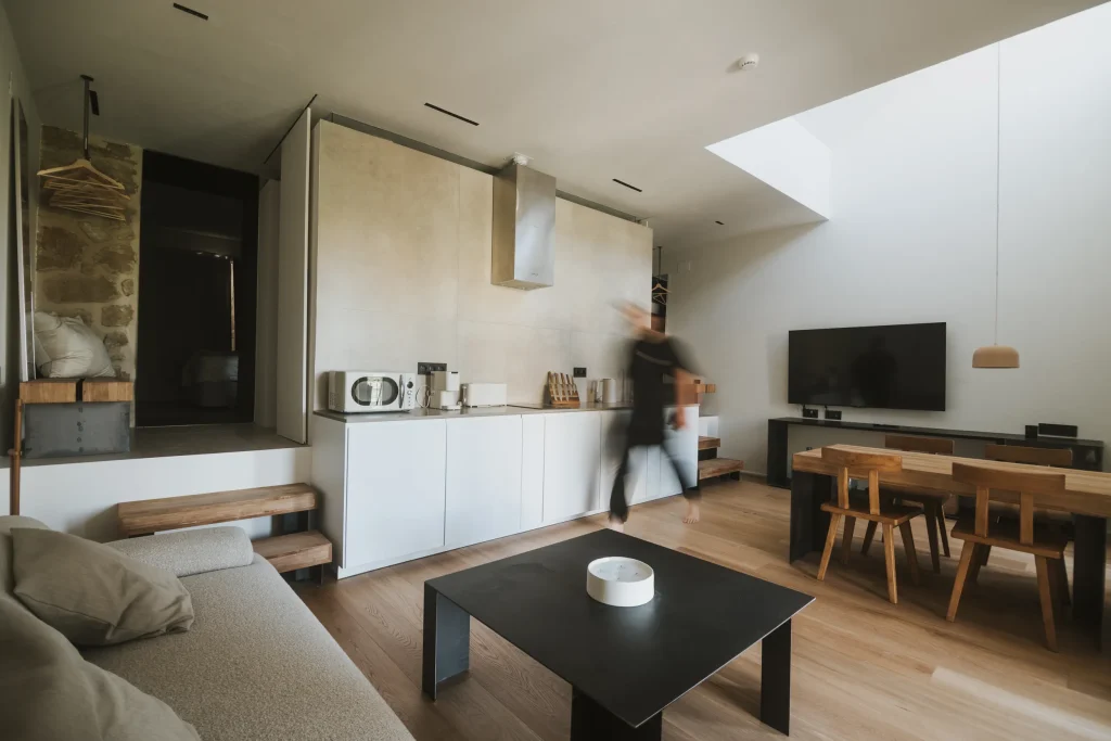 Cocina minimalista del apartamento 4 con armarios claros y campana integrada.