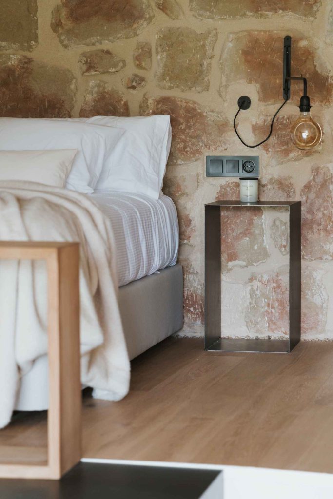Detalle de la cama del apartamento 2, con mesilla y lámparas de lectura.