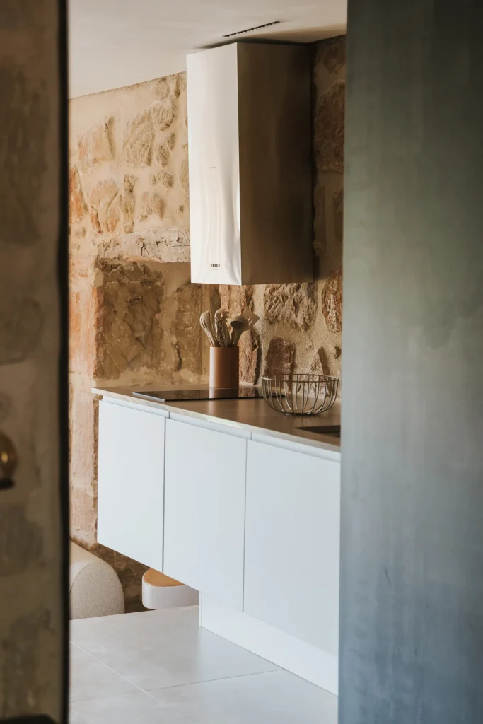 Cocina del apartamento 6 integrada con un muro de piedra original.