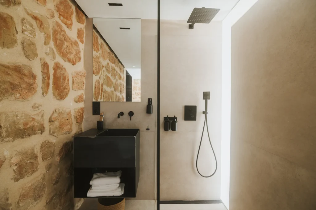 Baño luminoso del apartamento 6 con lavabo doble, espejo y ducha.