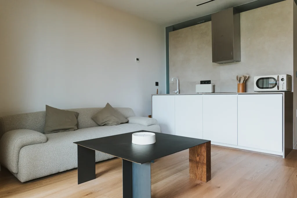 Cocina abierta y zona de estar del apartamento 3 en tonos claros.