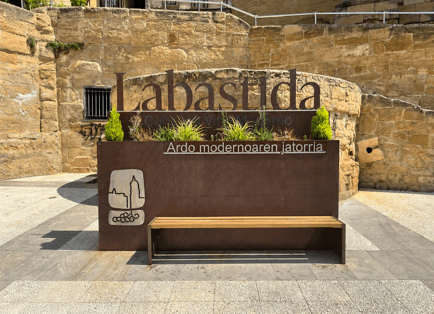 Cartel de entrada a Labastida ante un muro de piedra.